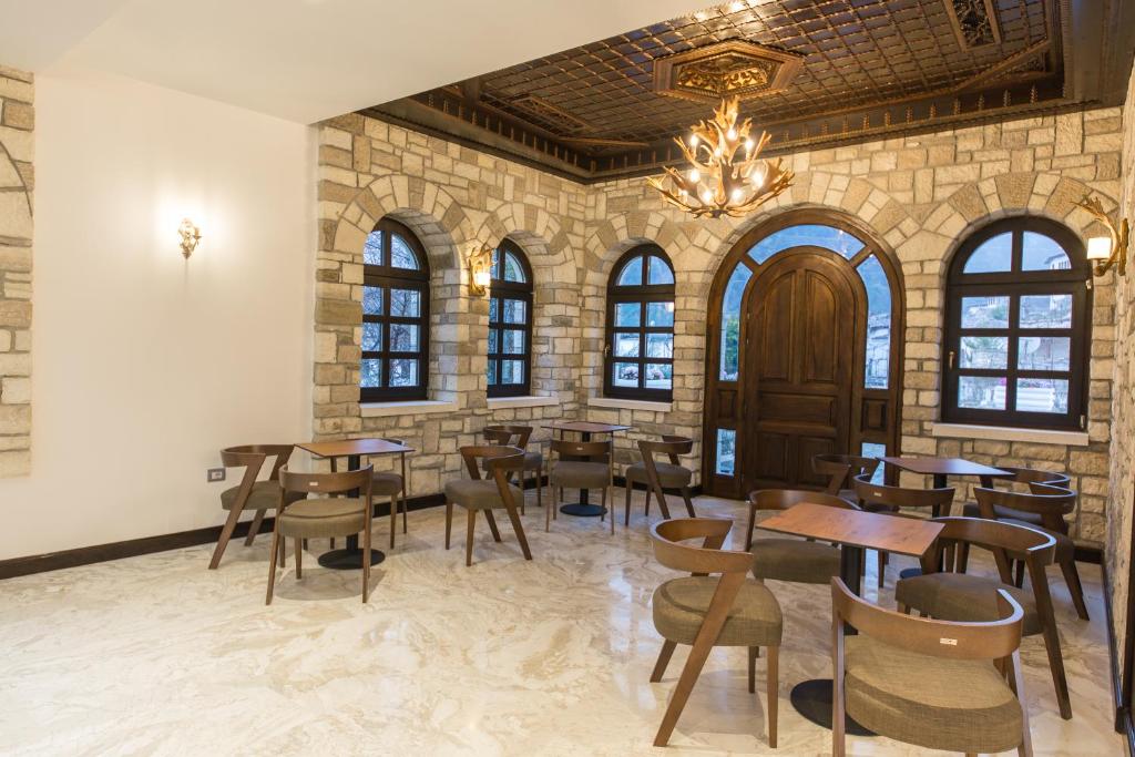 a restaurant with tables and chairs and a chandelier at Hotel Onufri in Berat