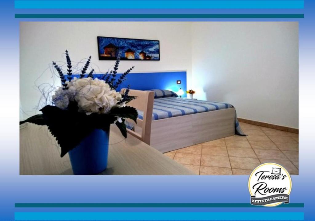 a bedroom with a bed and a vase of flowers at Teresa's apartments in Santa Domenica