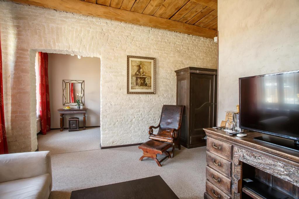 a living room with a television and a chair at A Boutique Apartments in Saint Petersburg