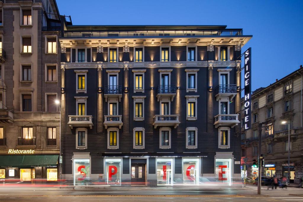 a large building on a city street at night at Spice Hotel Milano in Milan