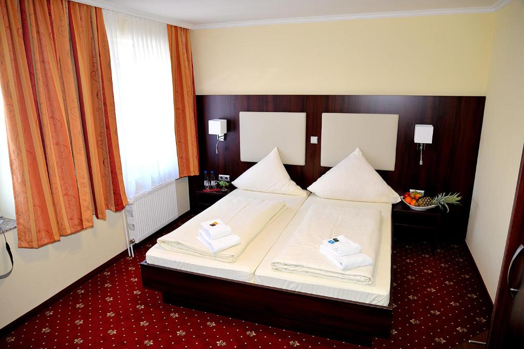 ein Schlafzimmer mit einem Bett mit zwei Handtüchern darauf in der Unterkunft Hotel Neugrabener Hof in Hamburg