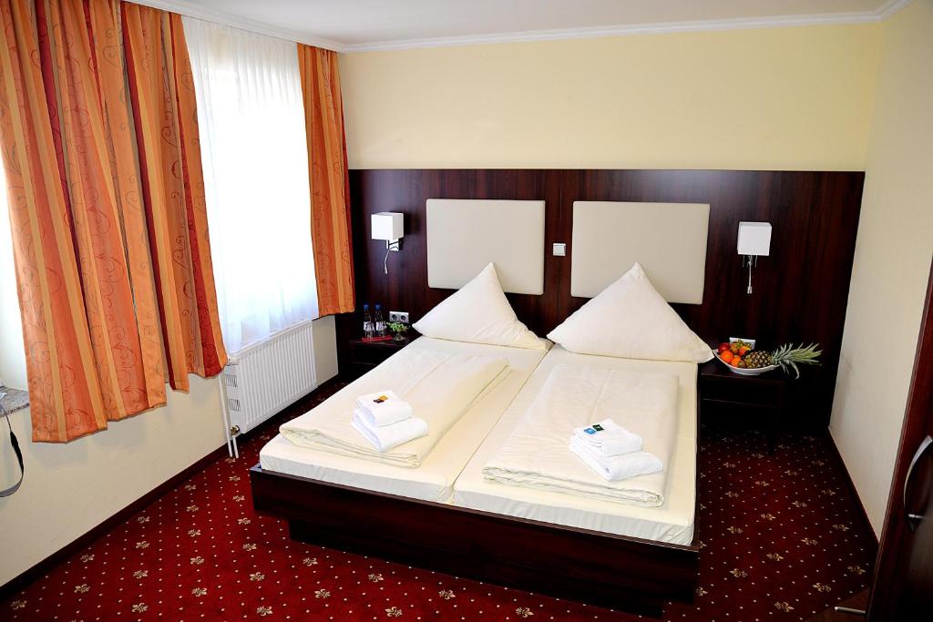 a bedroom with a bed with two towels on it at Hotel Neugrabener Hof in Hamburg