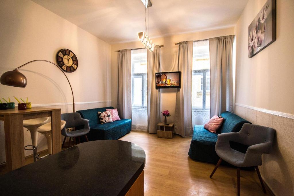 プラハにあるRiverside Ruterra Apartmentのリビングルーム(青いソファ、椅子付)