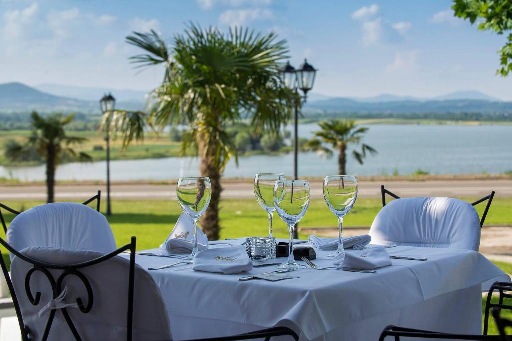 a table with wine glasses and a view of the water at My Soul Resort in Knić