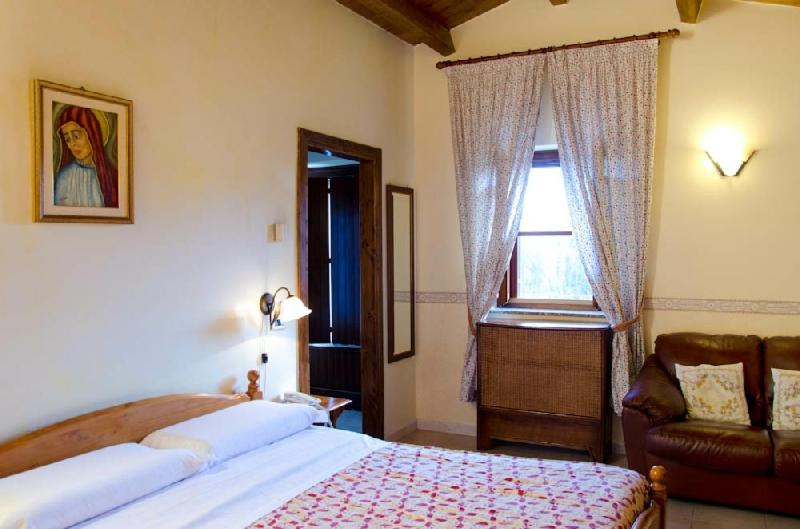 a bedroom with a bed and a window and a couch at Agriturismo Amicizia in Cassano delle Murge