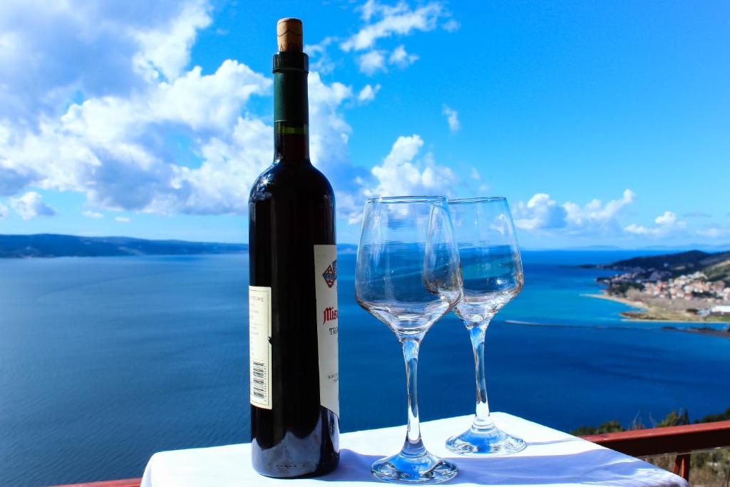 - une bouteille de vin et 2 verres à vin sur une table dans l'établissement Dalia, à Omiš