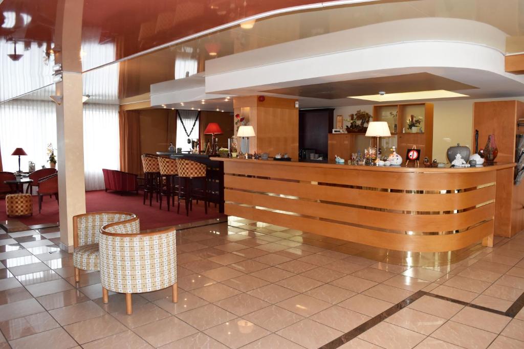 eine Lobby mit einer Bar und einigen Stühlen in der Unterkunft Hotel Le Pole Europeen in Aubange