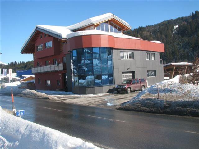 ein Gebäude mit einem davor geparkt in der Unterkunft Ferienwohnungen Ellmer in Flachau