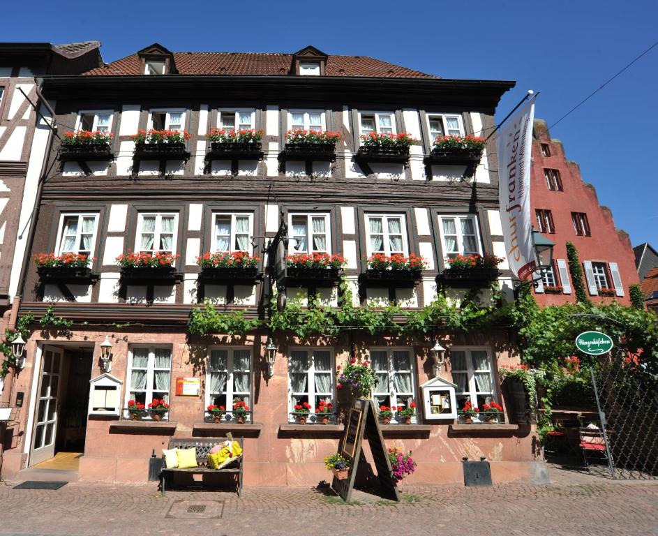 un bâtiment avec des boîtes de fleurs à l'avant dans l'établissement Wein-und Gasthof Zipf, à Miltenberg
