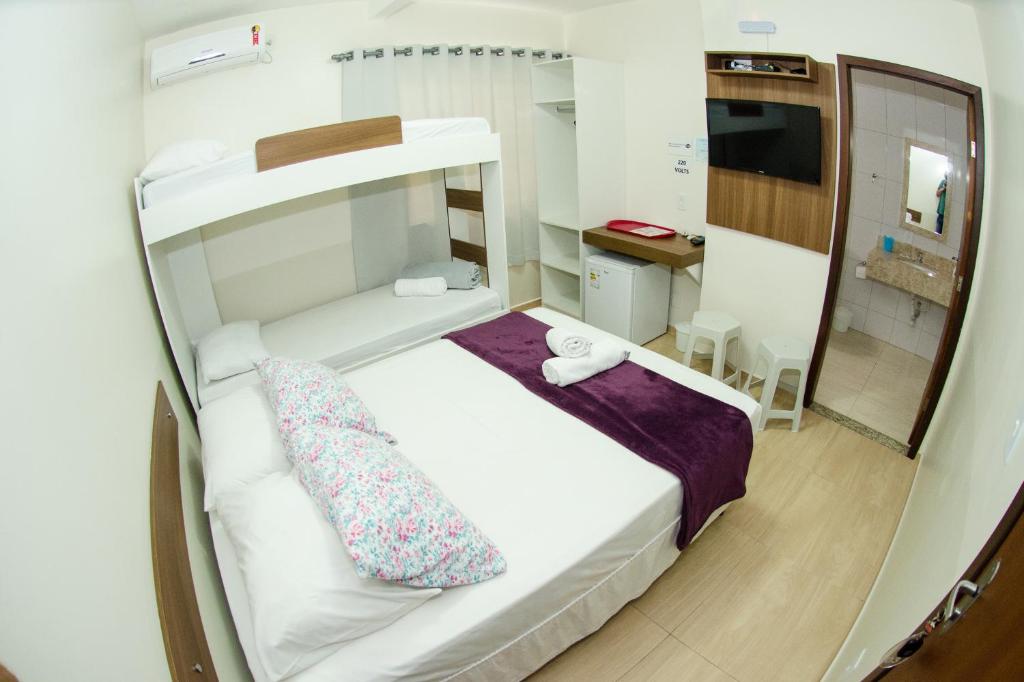 a small room with a bed and a mirror at Pousada Recanto dos Anjos in Penha