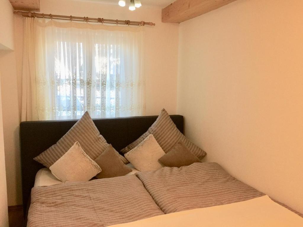 a bedroom with a bed with pillows and a window at Ferienwohnung CAI in Pfronten