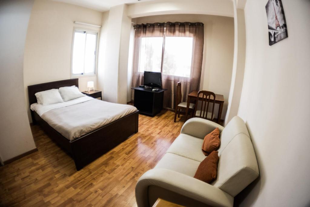 una camera con un letto, un divano e un letto di Elysium Capital Residence a Nicosia