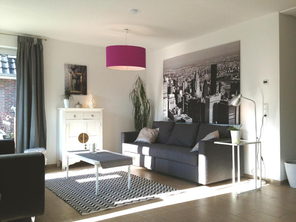 sala de estar con sofá y lámpara de color rosa en Gästewohnung Hygge, en Oldenburg
