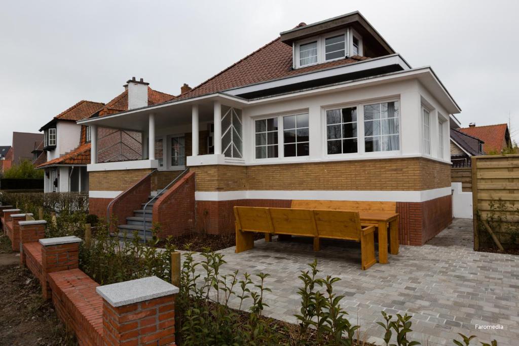 een huis met een bankje ervoor bij Villa Horizon in Koksijde