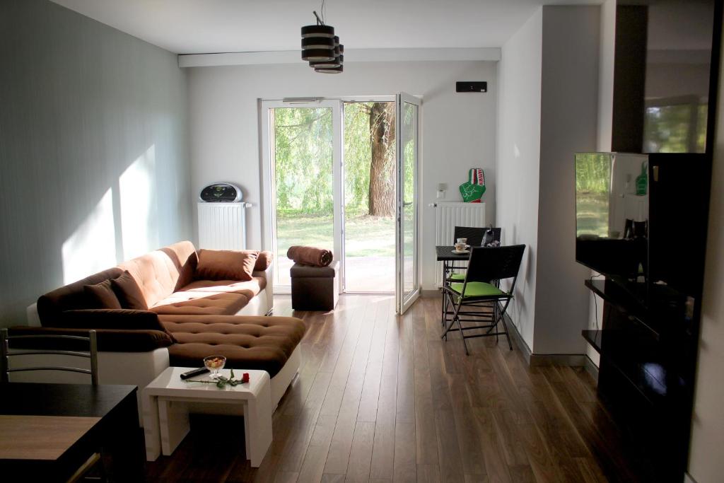 ein Wohnzimmer mit einem Sofa und einem Tisch in der Unterkunft Velence Resort Apartman in Velence