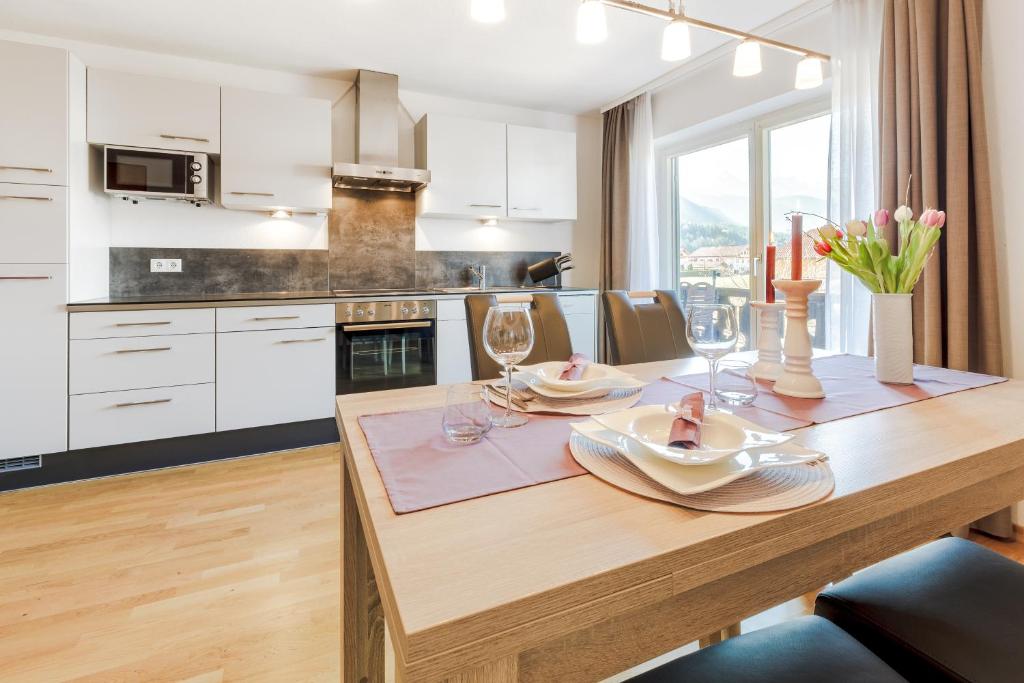 cocina con mesa de madera y copas de vino en Karwendellounge, en Krün