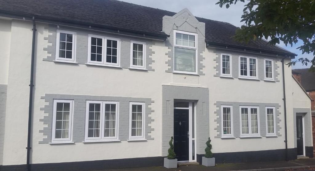 a white house with white windows and a door at Lamb Inn Guesthouse in Congleton