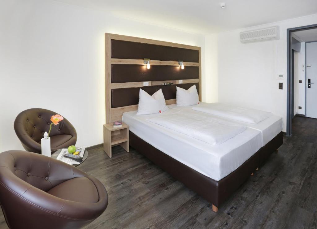 Postel nebo postele na pokoji v ubytování Roomingtons Kaiserhof Landshut