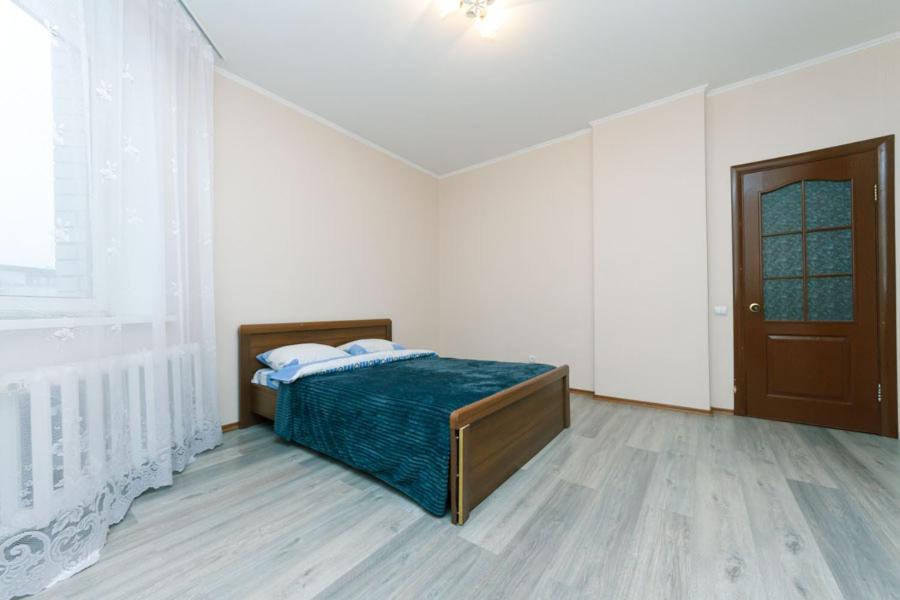 キーウにあるАхматовой 45のベッドルーム1室(ベッド1台付)、窓、ドアが備わります。
