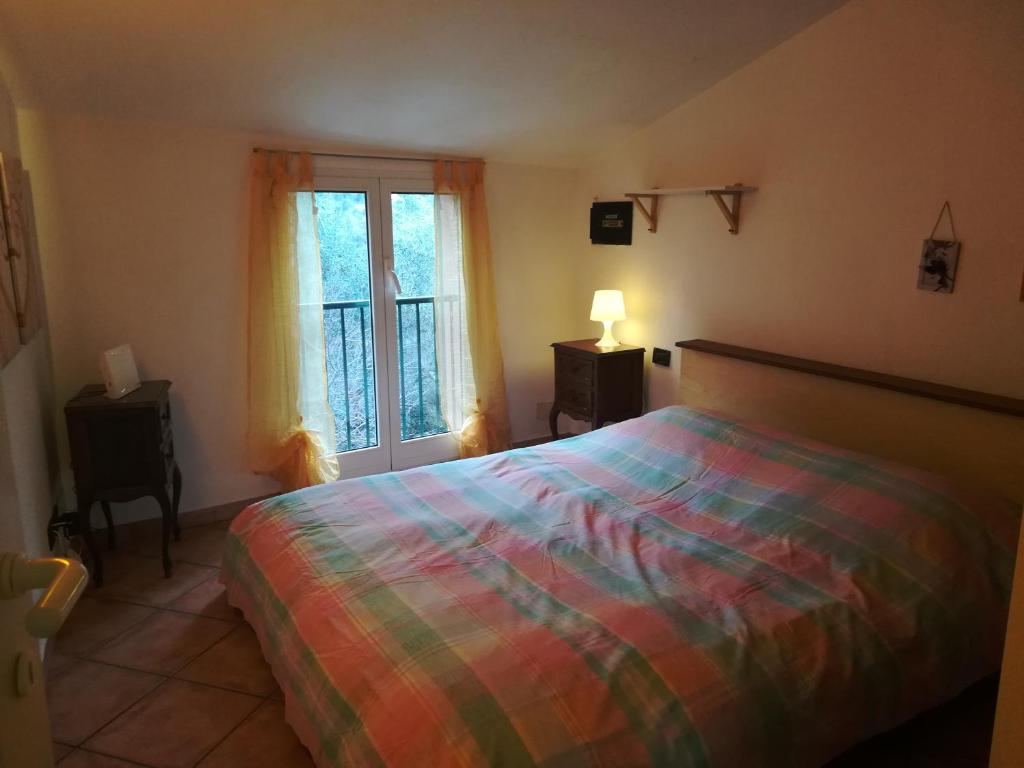 een slaapkamer met een bed en een raam bij Casa Burrasca in Levanto