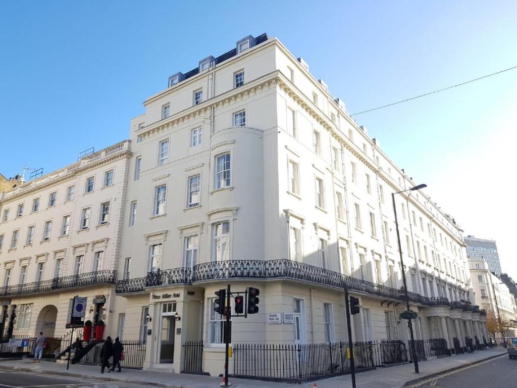 um edifício branco na esquina de uma rua em Prince William Hotel em Londres