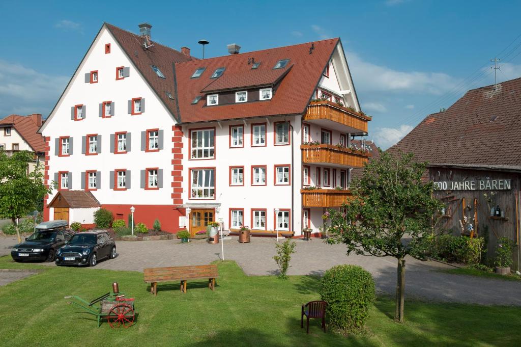 a large white building with a bench in front of it at Landgasthof Bären in Kirchzarten