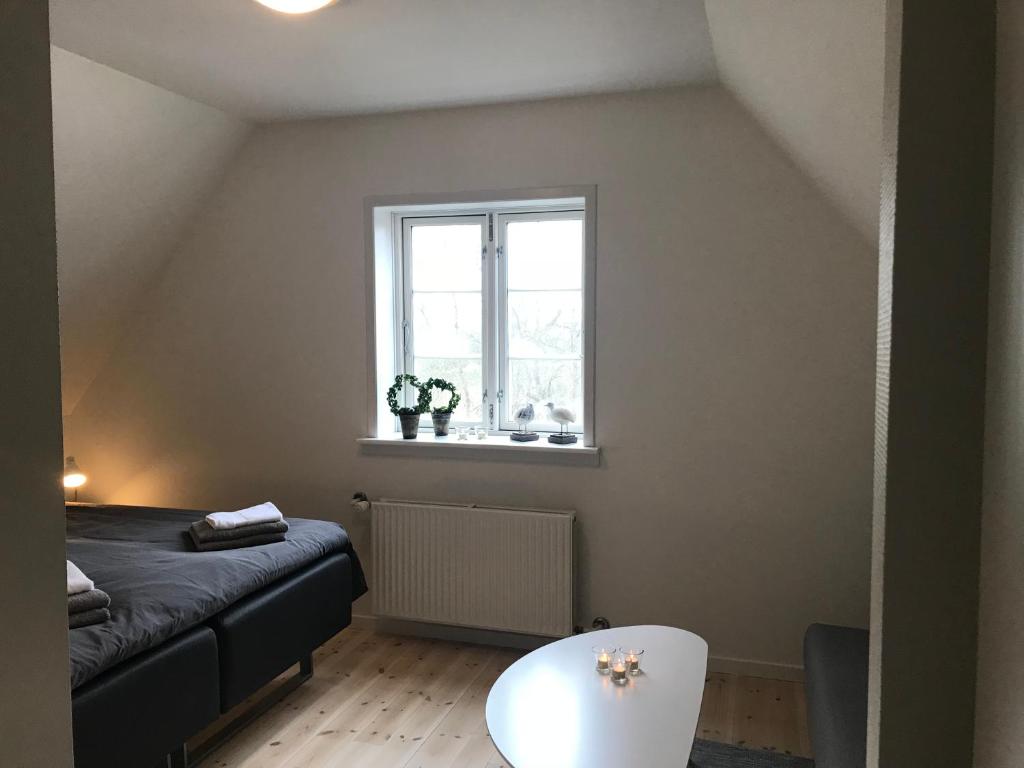 ein kleines Schlafzimmer mit einem Bett und einem Fenster in der Unterkunft Det Gamle Apothek in Haslev