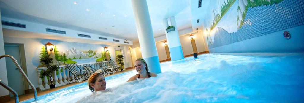dos niños en una piscina en un hotel en Hotel Kirchboden by Alpeffect Hotels, en Wagrain