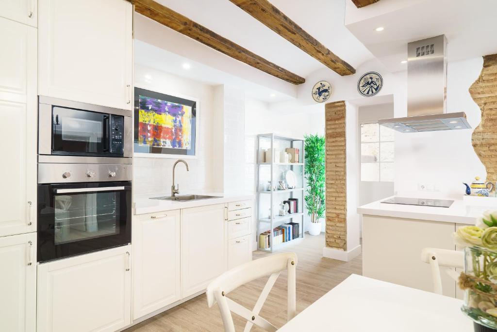 a kitchen with white cabinets and a sink at Vivaldi Center City in Valencia