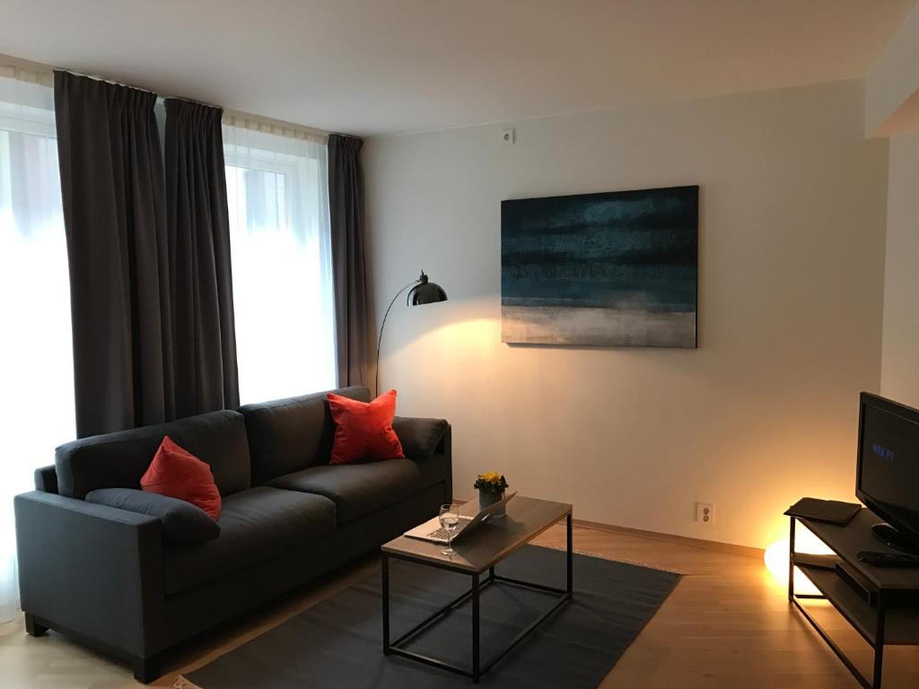 a living room with a couch and a tv at The Apartments Company - Aker Brygge in Oslo