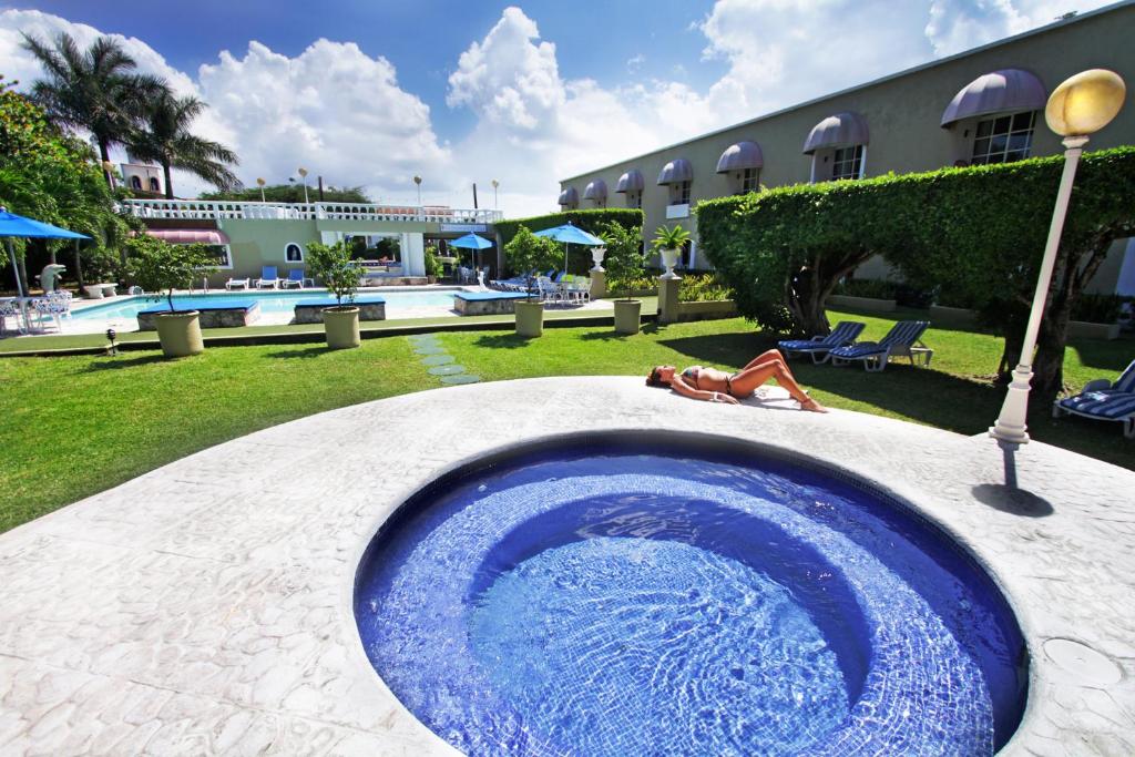 ein Pool mit einer blauen Schüssel in der Mitte eines Resorts in der Unterkunft Villablanca Garden Beach Hotel in Cozumel