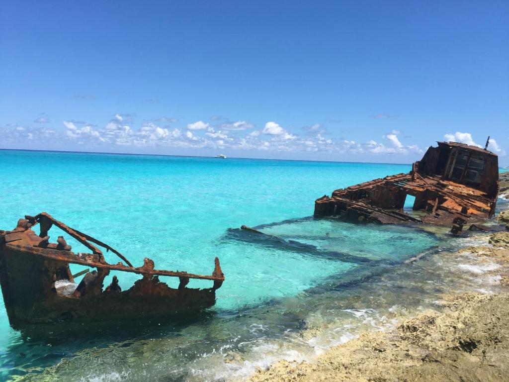 an old boat in the water on a beach at Bimini Seaside Villas - Pink Cottage with Beach View in Alice Town