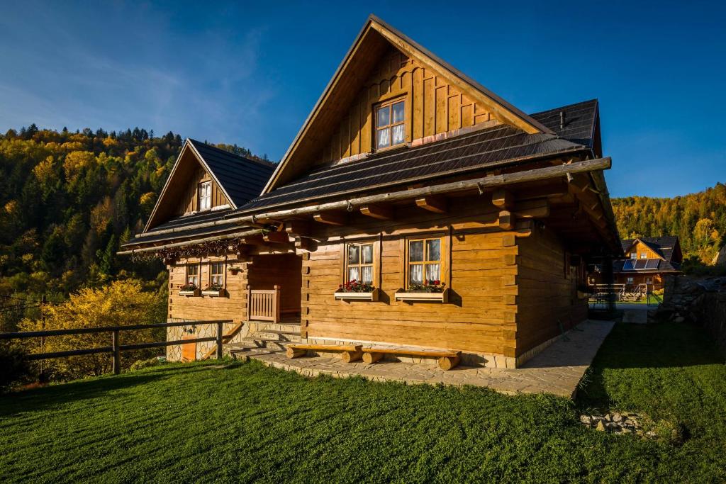 a wooden house with a bench in front of it at Chata Uhorčík in Terchová
