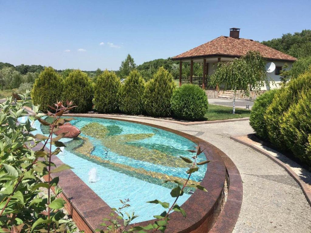 una piscina en un jardín con cenador en Vesyolaya Rochsha en Dniprodzerzhynsʼk