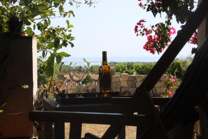 - une bouteille de vin et des verres assis sur une table dans l'établissement Dimora di Campagna con vista mare, à Menfi