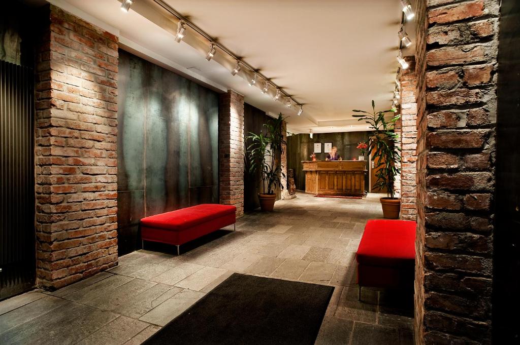 a hallway with red seats and a brick wall at Hotel Hellsten in Stockholm