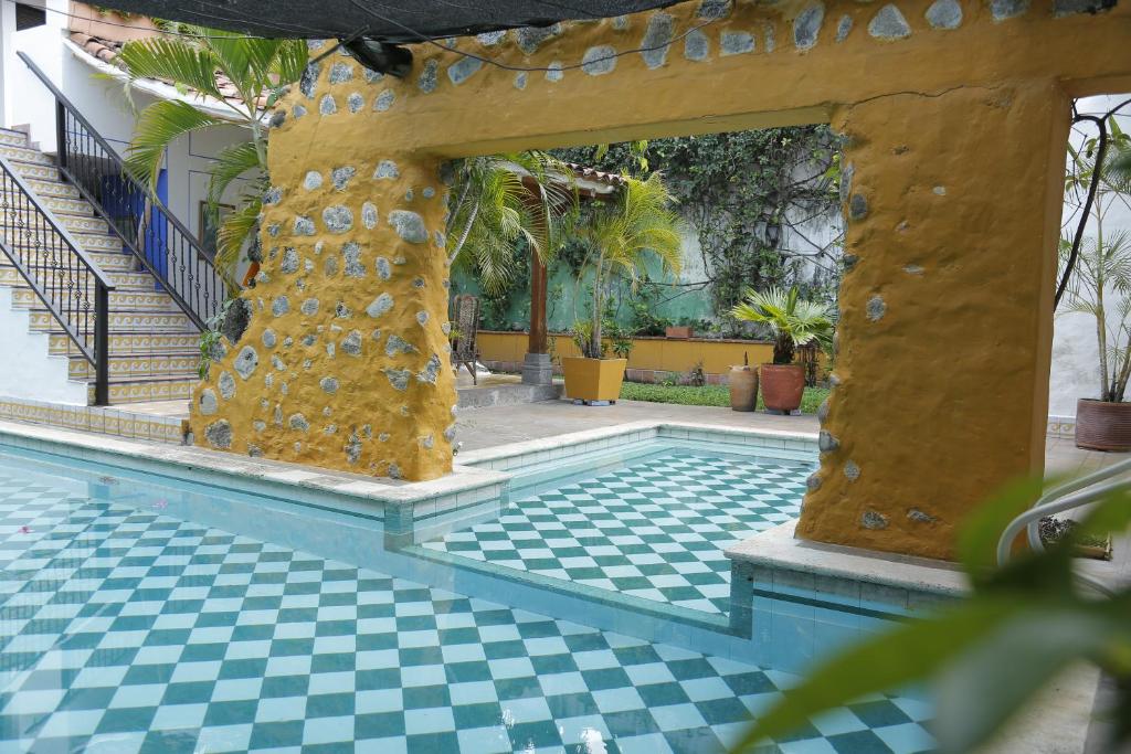 une piscine avec un sol en damier et un bâtiment dans l'établissement Casa Xanadu, à Honda