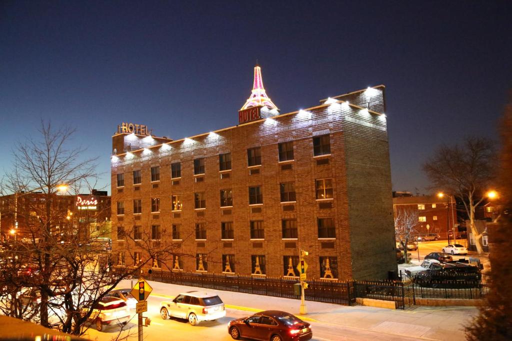 un grand bâtiment en briques avec des lumières au-dessus dans l'établissement Paris Suites Hotel, à Queens