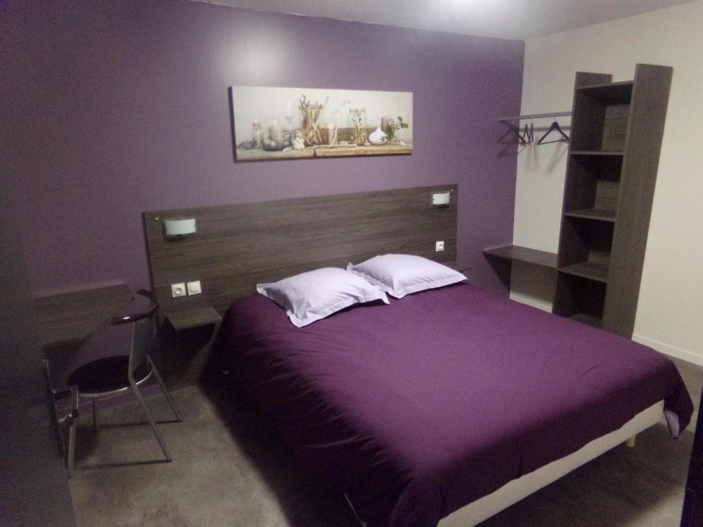 ein lila Schlafzimmer mit einem Bett und einem Schreibtisch in der Unterkunft Hôtel La Tente Verte in Loon-Plage
