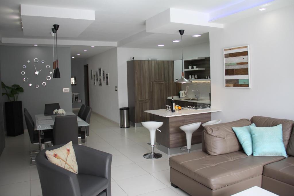 a living room with a couch and a kitchen at Interlace Apartment with free parking in Marsaskala
