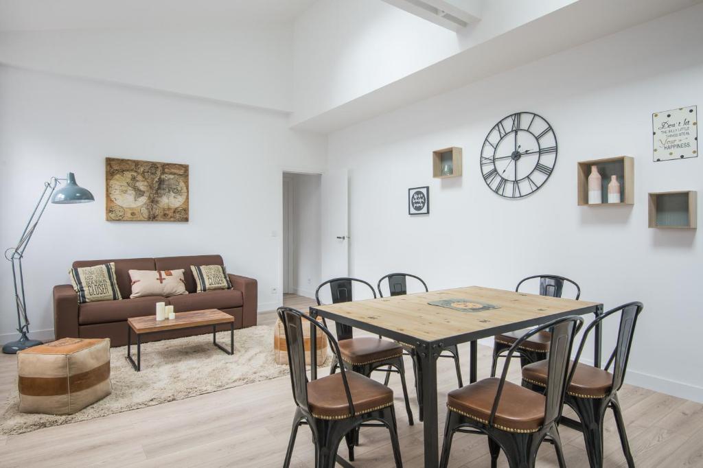 un salon avec une table, des chaises et un canapé dans l'établissement L'Industriel, loft de 2 chambres, Villa Saint Charles, à Paris