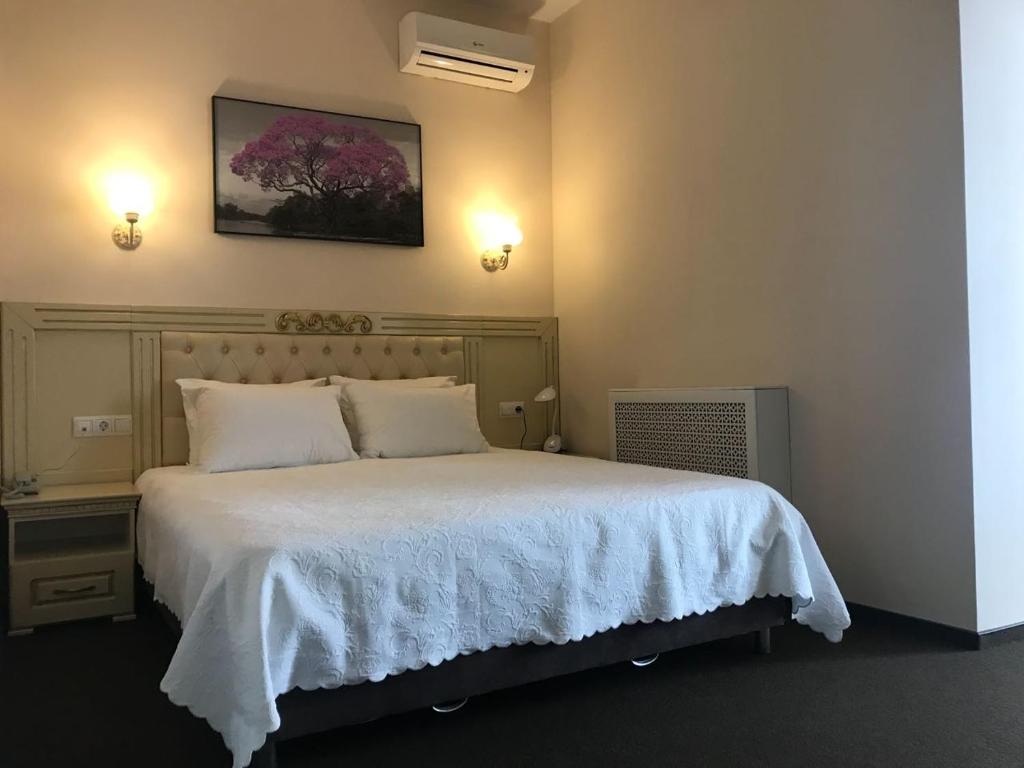sypialnia z dużym łóżkiem i białym kocem w obiekcie Hotel Prospekt Mira w mieście Rieutow