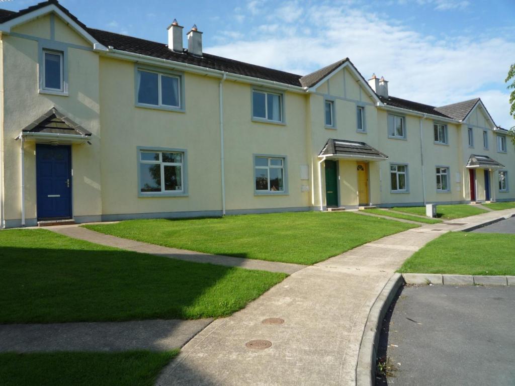 una gran casa blanca con un patio de césped en Forest Haven Holiday Homes, en Dunmore East