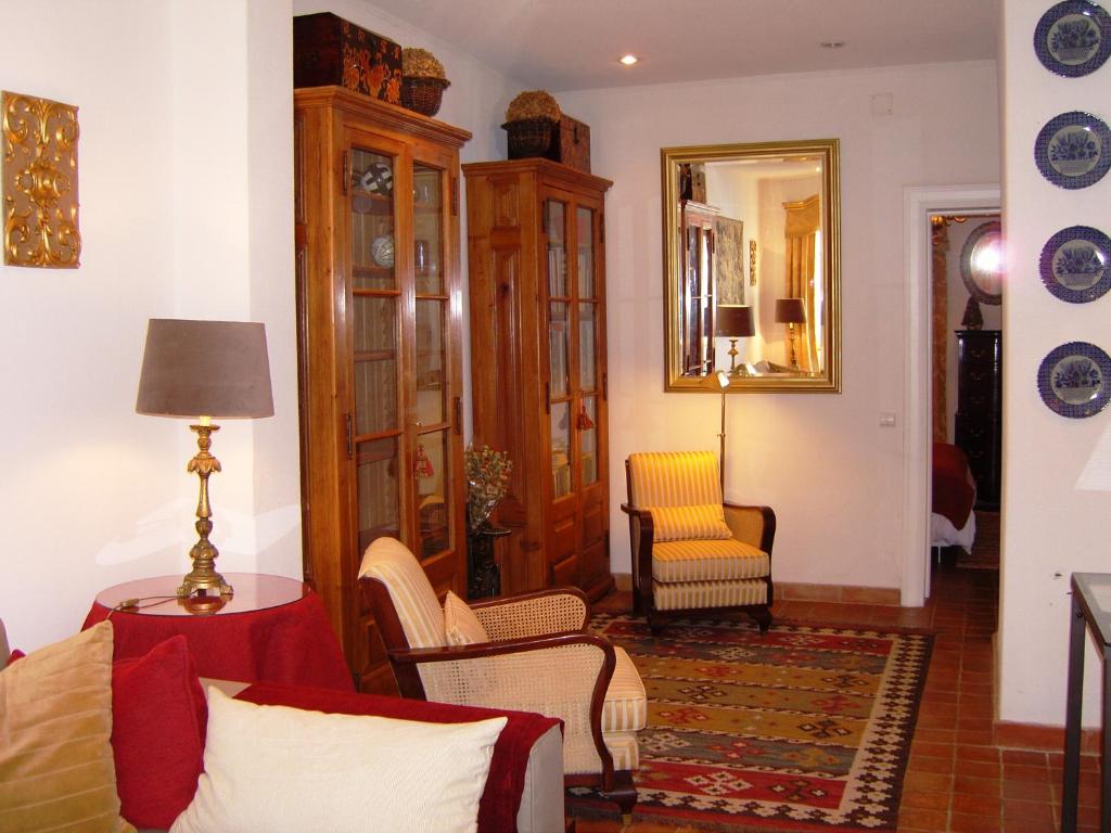 a living room with a couch and chairs and a mirror at Estrela Park in Lisbon