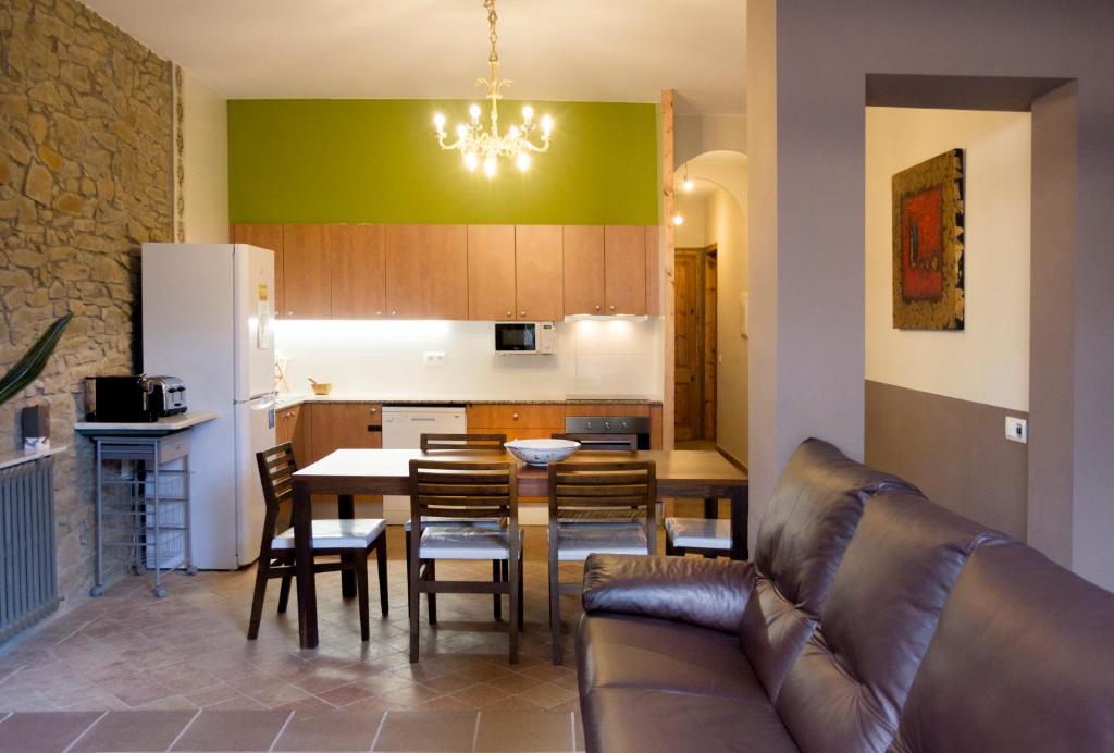 a kitchen and dining room with a couch and a table at Gallaret in Sant Juliá de Vilatorta