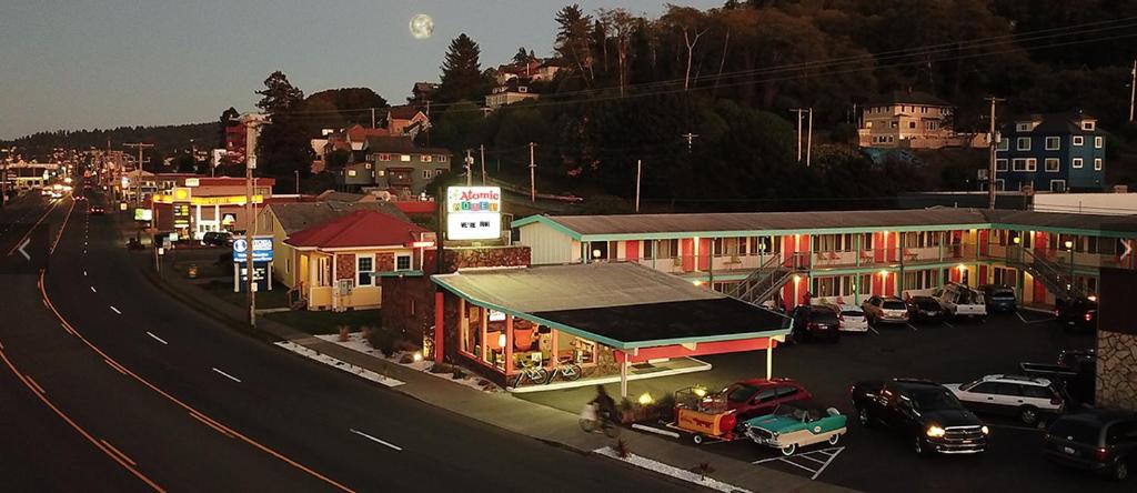 een stadsstraat met auto's geparkeerd op een parkeerplaats bij Atomic Motel in Astoria, Oregon