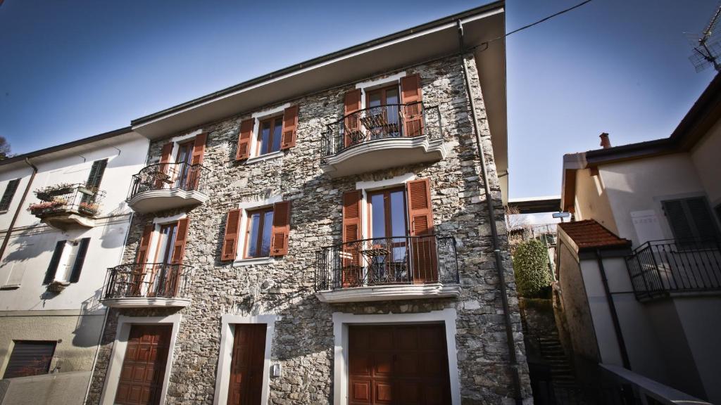 - un vieux bâtiment en pierre avec des fenêtres et des balcons dans l'établissement Casa della Vittoria, à Maccagno Inferiore