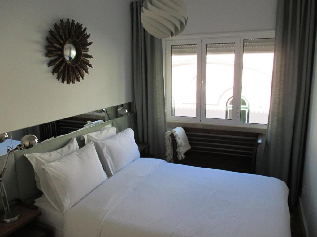 リスボンにあるPríncipe Real Sunnyのベッドルーム(白いベッド1台、窓付)
