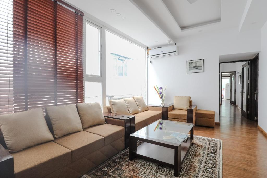een woonkamer met een bank en een salontafel bij Orania B & B by Atsar in New Delhi