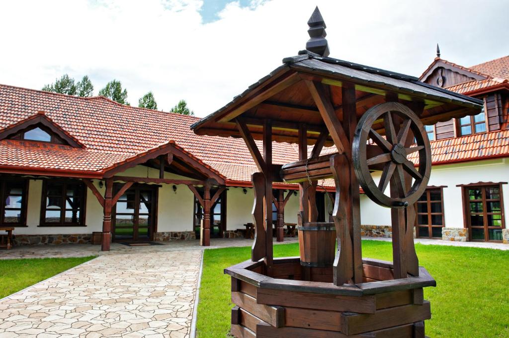 a statue of a wheel in front of a building at Hotel Chutor Kozacki in Łukowe